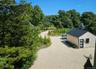 Surrounding community featuring an outbuilding, gravel driveway, and a wooded view