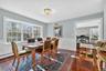 Dining room featuring a decorative wall, wainscoting, and dark wood-type flooring
