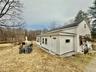 Unit 1 - View of property exterior with roof with shingles and a lawn