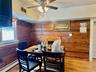 3 - Dining room featuring visible vents, wooden walls, a ceiling fan, baseboard heating, and light wood-type flooring
