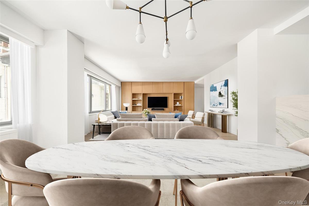 Open-concept interior featuring light wood-finish flooring and a central chandelier