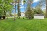 View of green lawn featuring a storage shed