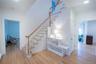 Staircase featuring baseboards, a baseboard heating unit, crown molding, and wood finished floors