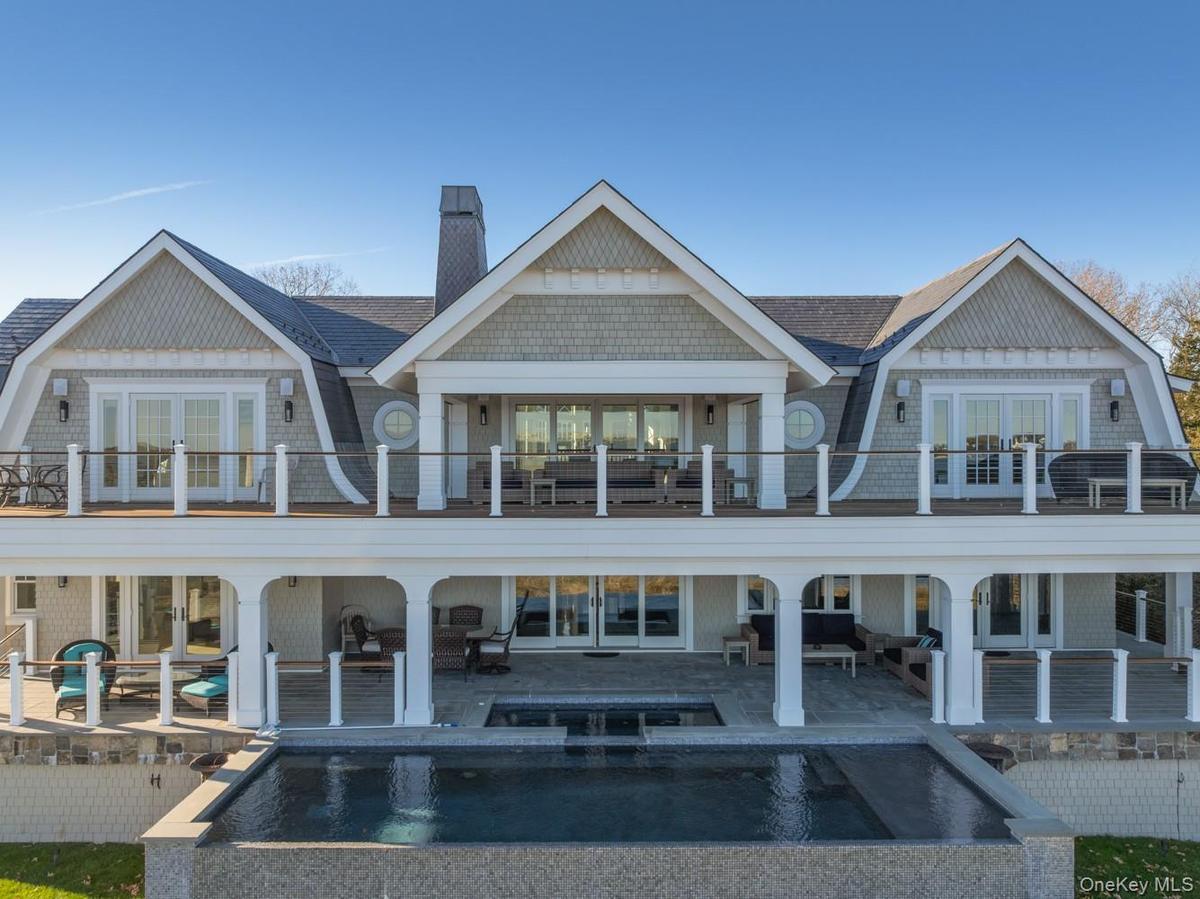 Back of property with a gambrel roof, french doors, and a patio