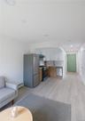 Living area featuring light wood-style flooring, a baseboard heating unit, and recessed lighting