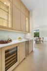 Bar area with glass insert cabinets, backsplash, beverage cooler, light brown cabinetry, and recessed lighting