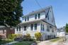 Two-story white residence featuring horizontal siding and shake shingles