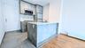 Kitchen featuring stainless steel appliances, a baseboard radiator, a peninsula, modern cabinets, and light stone counters