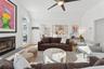 Living room featuring vaulted ceiling,  wood  floors, fireplace, and ceiling fan