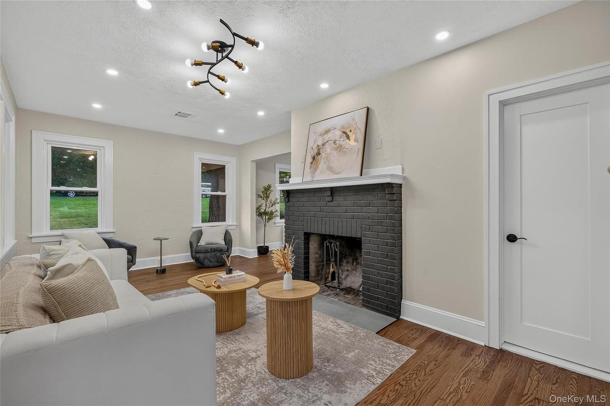 Living area with a painted brick fireplace, white mantel, and slate hearth
