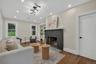 Living area with a painted brick fireplace, white mantel, and slate hearth