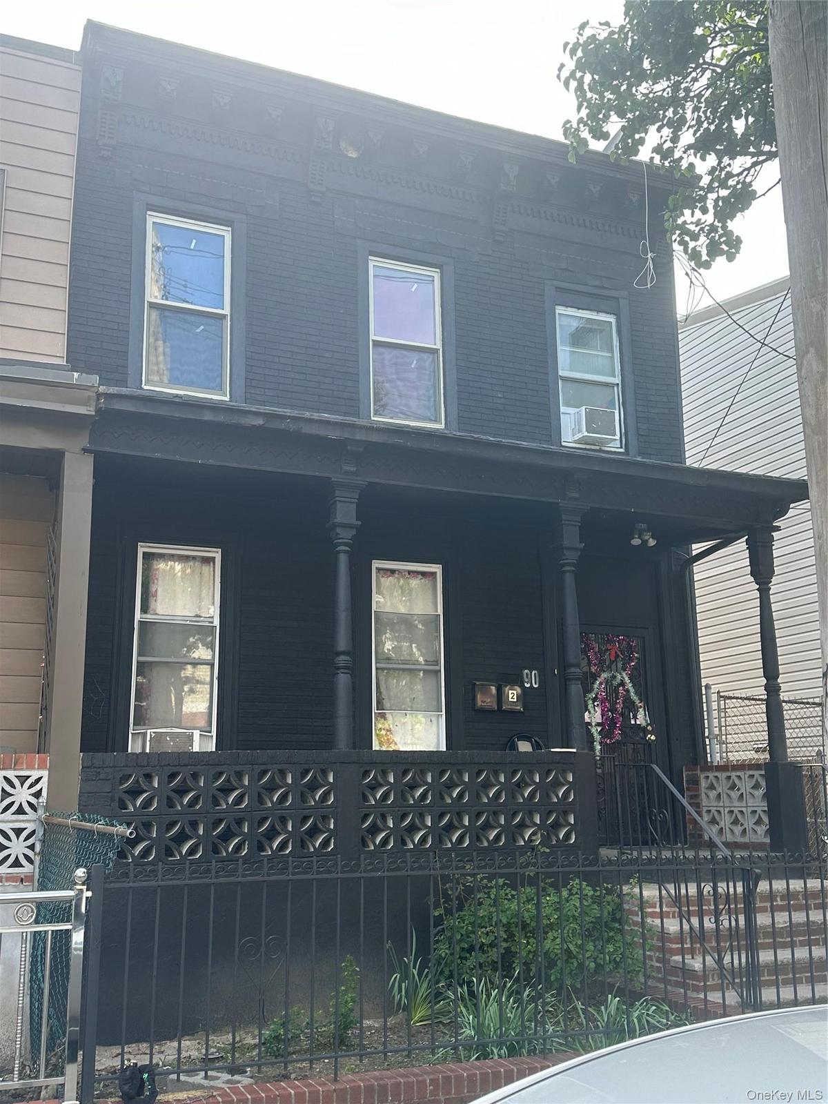 View of front facade with a porch, a fenced front yard, and central air condition unit