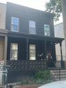 View of front facade with a porch, a fenced front yard, and central air condition unit