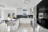 Kitchen featuring appliances with stainless steel finishes, a kitchen bar, a peninsula, decorative backsplash, and white cabinets