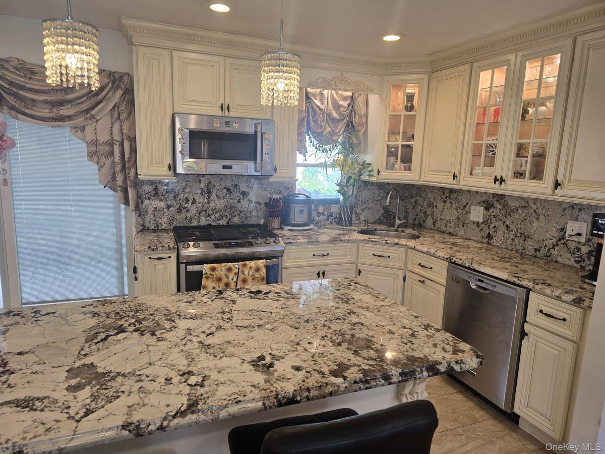 Kitchen featuring cream-colored cabinetry with decorative molding