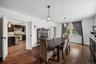Elegant formal dining room featuring rich hardwood flooring, stylish pendant lighting, and oversized windows that provide abundant natural light. Thou