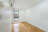 Empty room featuring light wood-type flooring, a wall mounted air conditioner, and recessed lighting
