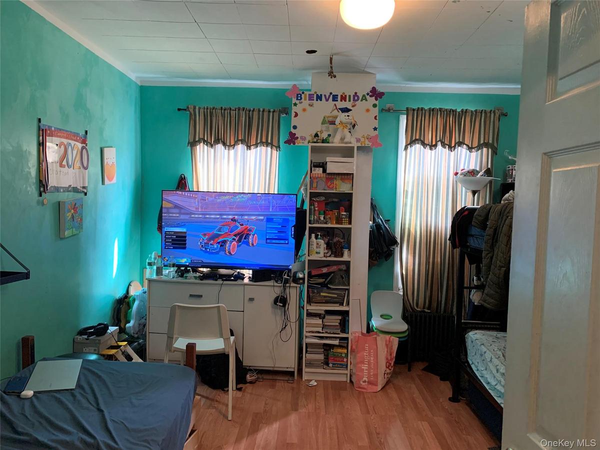 Bedroom featuring wood finished floors and ornamental molding
