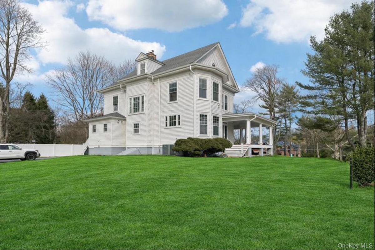 Rear view of property with a yard, a chimney, and a sunroom