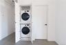 Laundry room featuring baseboards and stacked washer and clothes dryer