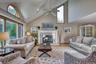 Living room with high vaulted ceiling, wood finished floors, a premium fireplace, recessed lighting, and a ceiling fan