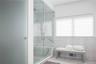 Full bathroom featuring a marble finish shower, a wealth of natural light, and visible vents