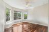 2nd level guest bedroom with bay windows with a window seat with storage.