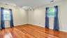 Empty room with rail lighting, light wood-style floors, visible vents, and baseboards