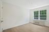 Bedroom with dimmable overhead lighting, wood floors, large closet and remote controlled motorized shades