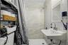 Bathroom featuring a wall-mounted sink, medicine cabinet with mirror, and shower with tiled walls