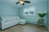 Living room with light hardwood / wood-style floors, ceiling fan, and a baseboard heating unit