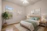 A comfortable secondary bedroom with flexible space for family members or overnight guests. - virtually staged