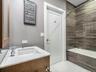 The full bath features a relaxing soaking tub, white marble countertops, and elegant marble flooring.