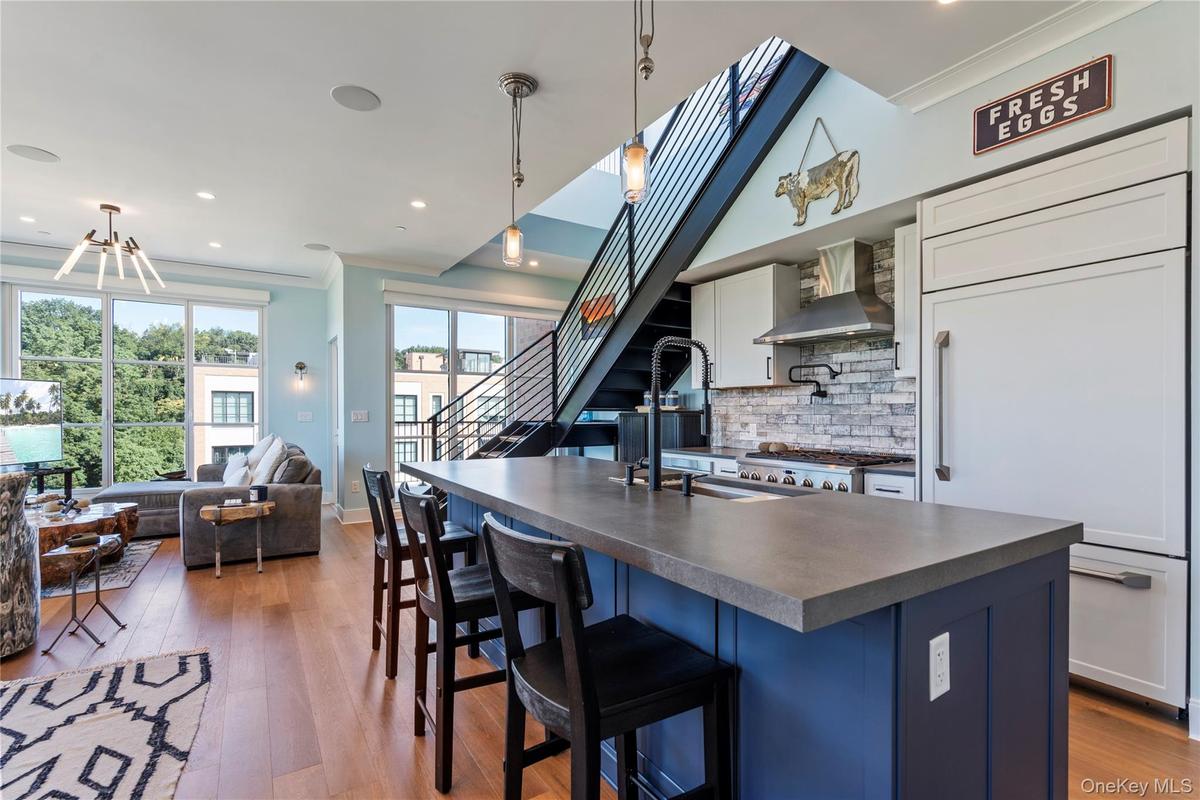 Kitchen with crown molding, a kitchen island, blue cabinetry, decorative backsplash