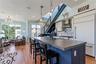 Kitchen with crown molding, a kitchen island, blue cabinetry, decorative backsplash