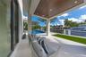 On the first floor, a guest room opens to a covered patio with breathtaking waterfront views,