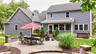 Expansive paver patio with a stone wall, offering direct access to the screened porch and a dedicated space for outdoor entertaining