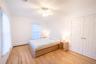 Unfurnished bedroom with a closet, light wood-style flooring, baseboard heating, ornamental molding, and ceiling fan