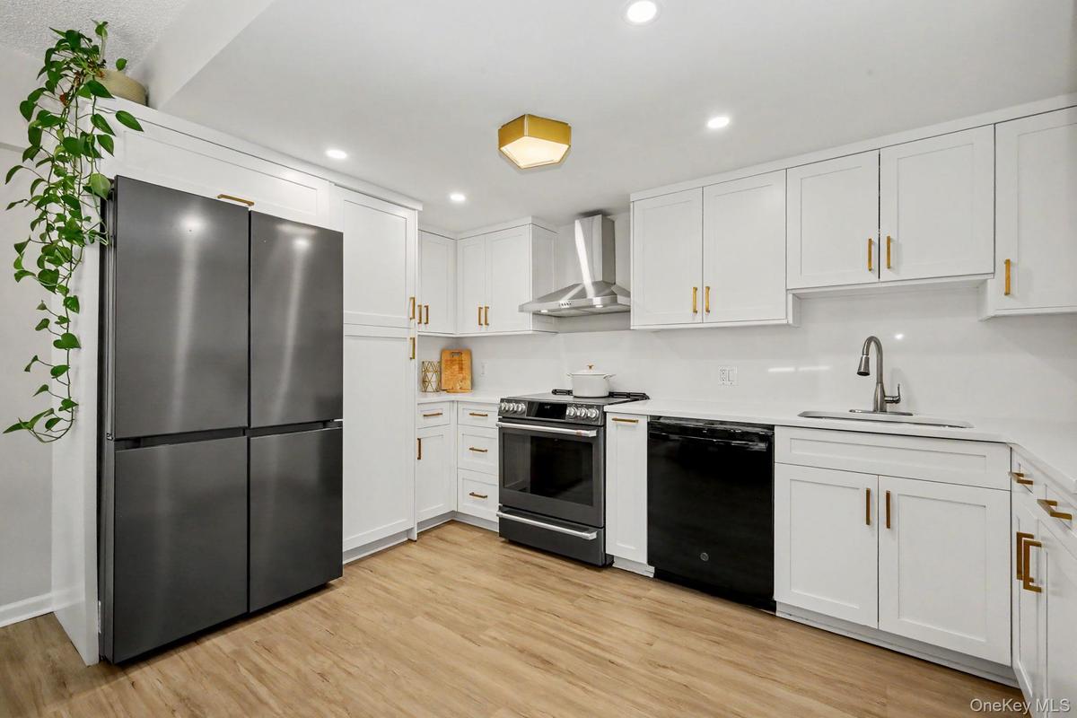 The spacious, beautifully renovated kitchen is both stylish and functional, featuring top-of-the-line appliances, gorgeous flooring, and generous coun