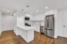 Kitchen with stainless steel appliances, white cabinetry, and a peninsula