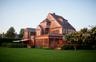 Back of property featuring a sunroom, a lawn, and a chimney