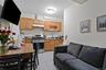Ground Floor compact kitchen featuring wood cabinetry, stainless steel range, and grey tile flooring