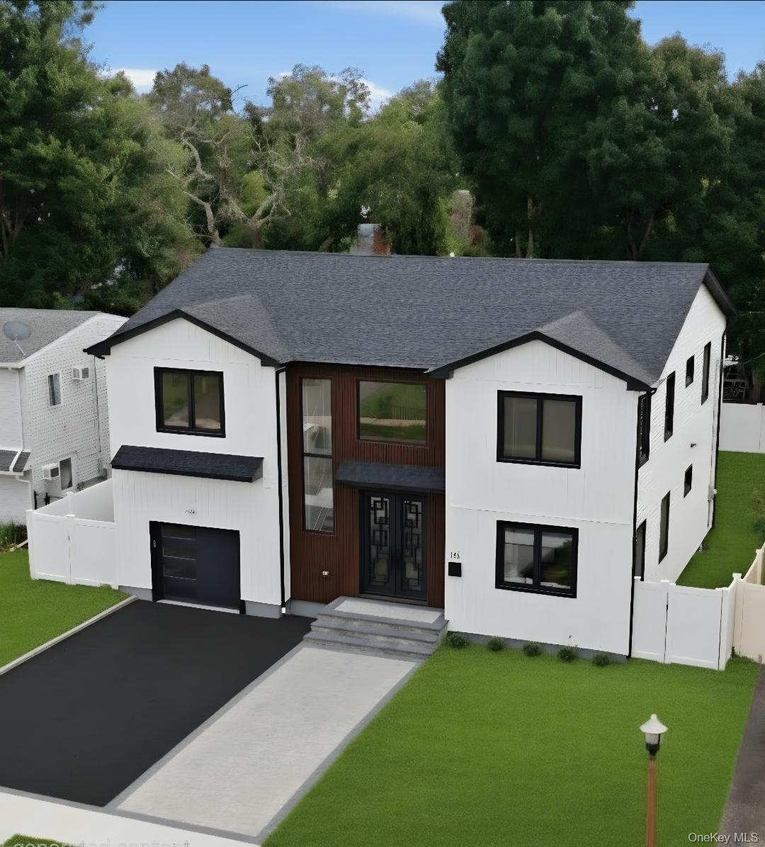 Contemporary two-story residence featuring a white vertical siding facade with dark trim accents