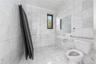 Bathroom featuring toilet, tile walls, and a sink