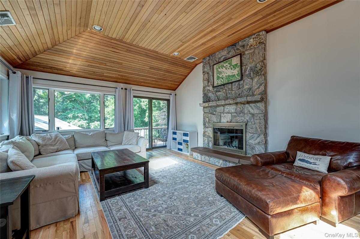Living room with wood burning stove & sliders to side deck overlooking back yard