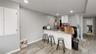 Kitchen with white cabinetry, a breakfast bar, stainless steel refrigerator, and light hardwood / wood-style flooring