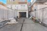 View of patio with a garage, concrete driveway, and fence