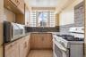 Kitchen featuring white appliances, a sink, light brown cabinets, light tile patterned floors, and tasteful backsplash