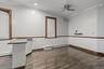 Unfurnished room featuring crown molding, baseboard heating, dark wood finished floors, and a ceiling fan