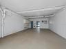 The covered parking with the doors open through the ground floor bonus room